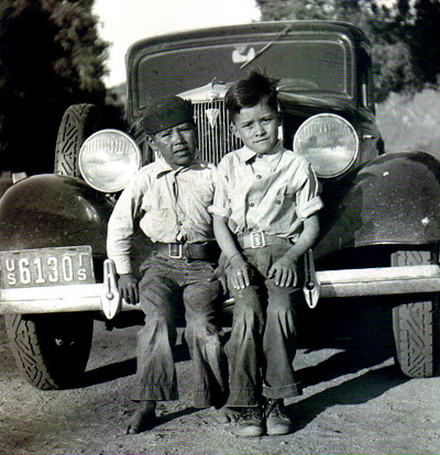 Boys sitting on car bumper